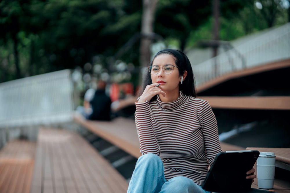 Girl sitting on a bleacher with her hand under her chin