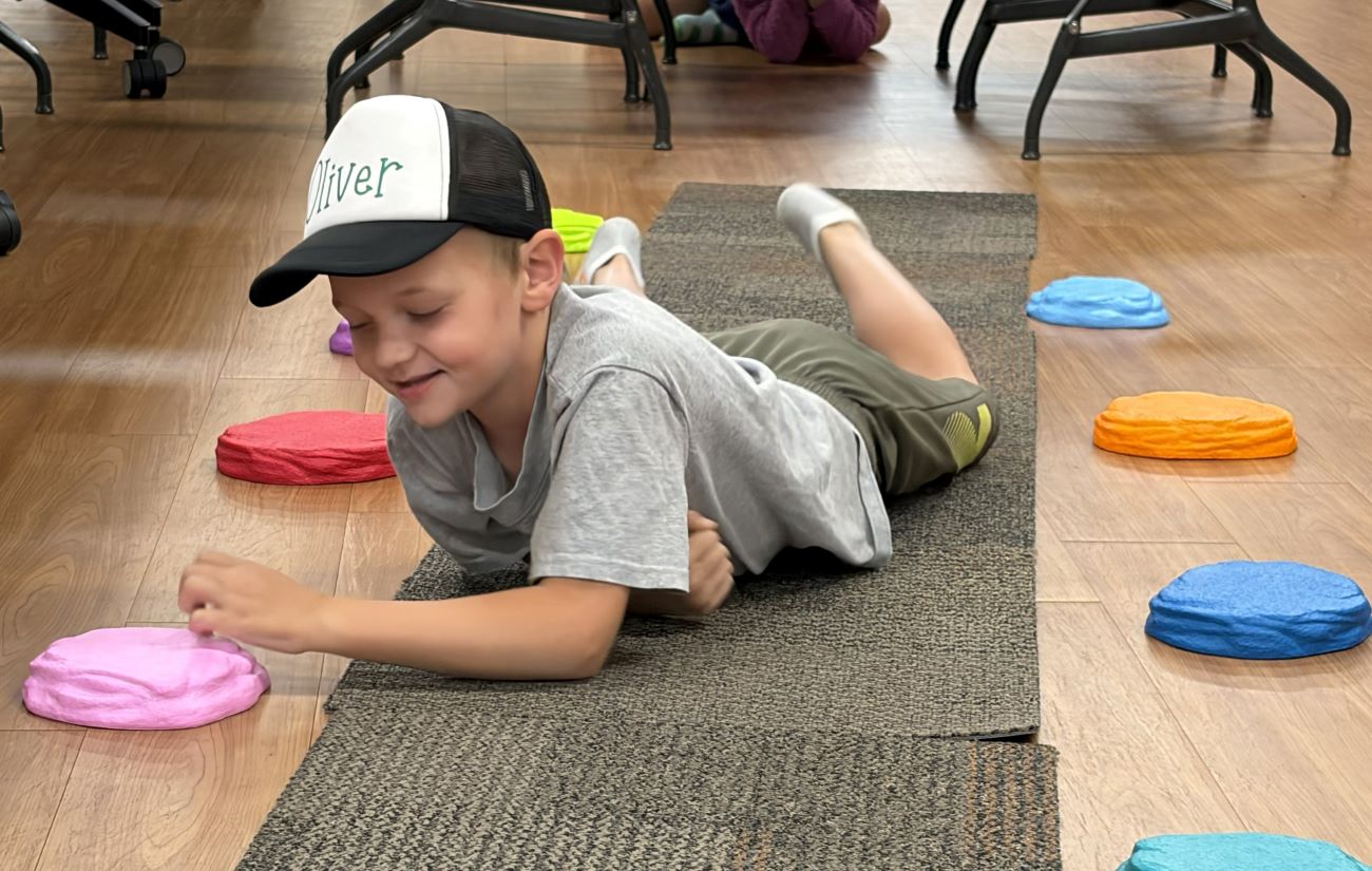 boy on ground with plastic colored dots