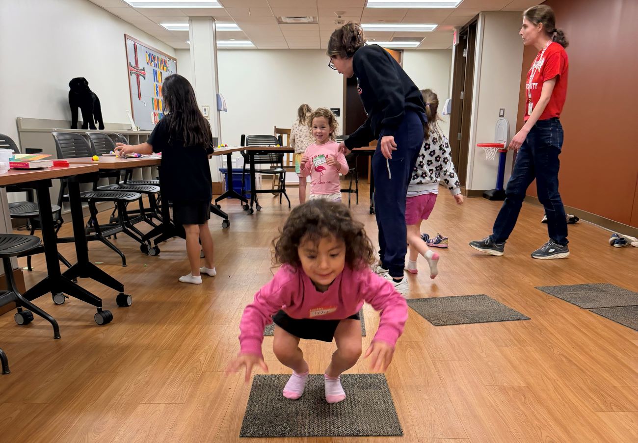 kid on mat in pink shirt