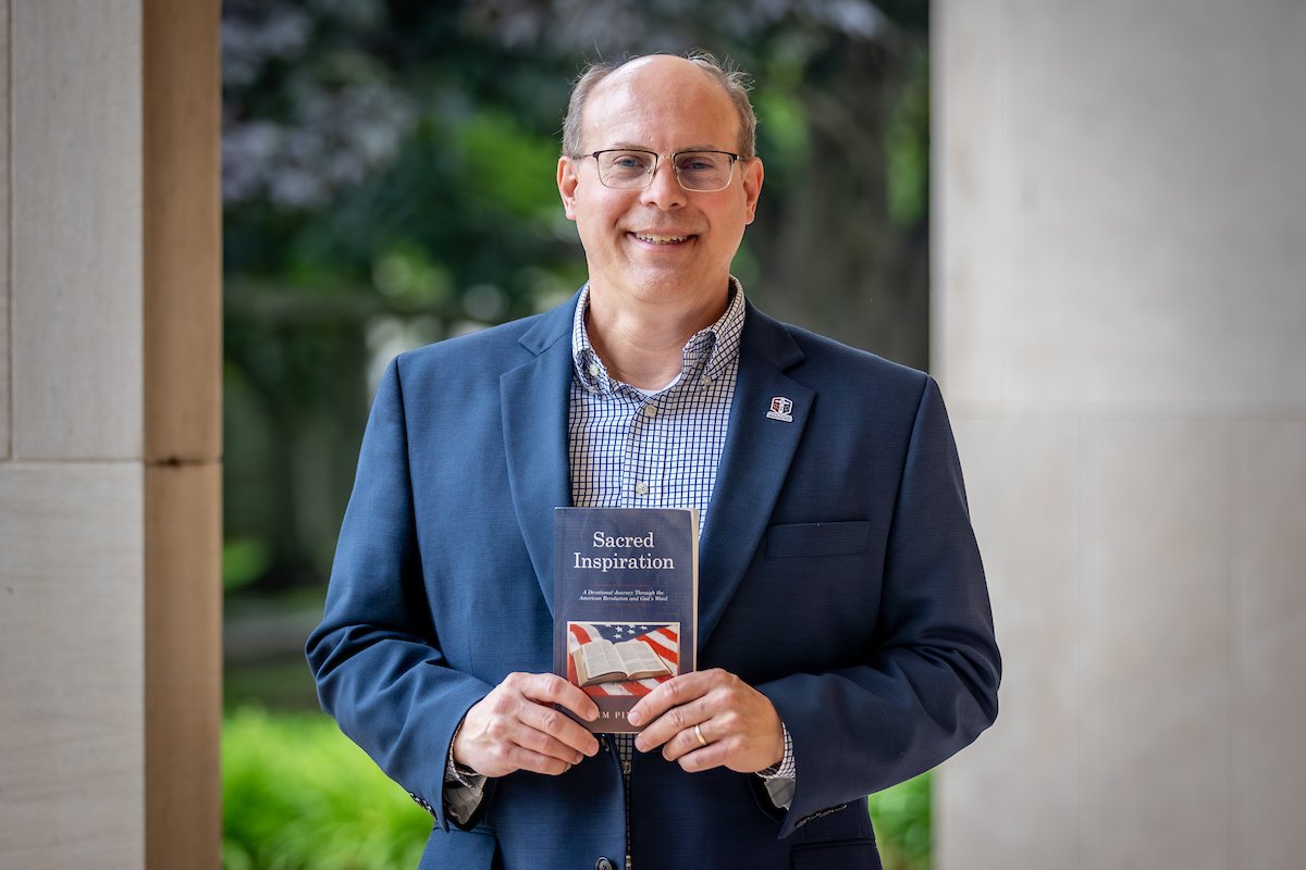 Jim Pingel holding the book he wrote.