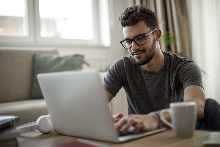 Man sitting at desk typing on computer.